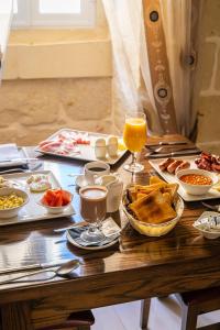 沙拉Il-Logga Boutique Hotel的餐桌上放有食物和橙汁的盘子