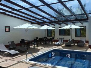 马萨米特拉Cabañas Mazzatl 6 pax的一个带游泳池、桌子和遮阳伞的庭院