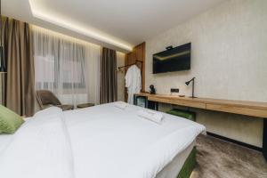 克拉古耶瓦茨Boutique Luxury Apartments的酒店客房设有一张大床和一台电视。