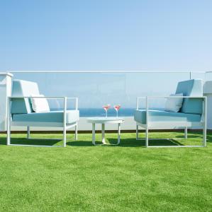 罗列特海岸Hotel Lloret Santa Rosa by Pierre & Vacances的美景草坪上配有两把椅子和一张桌子