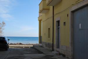 托雷坎内Casa sul mare的毗邻海滩的黄色建筑,与大海