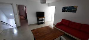 马德普拉塔Casa en Bosque Peralta Ramos的客厅配有红色沙发和电视