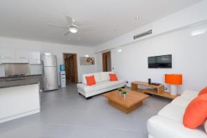 拉斯特拉纳斯Aligio Apart-hotel & Spa - Las Terrenas的一间带2张白色沙发的客厅和一间厨房
