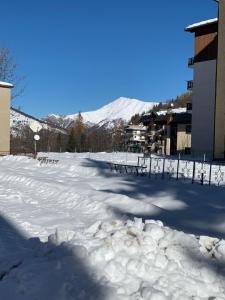 利莫内皮埃蒙特Casa Olivera的一个有雪盖的停车场,后方是一座山