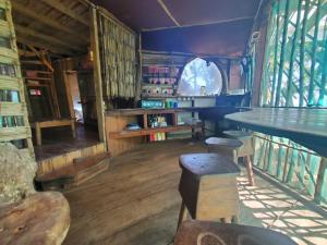 小玉米岛Derek's Place Eco-Lodge的一间设有桌子、椅子和书籍的房间