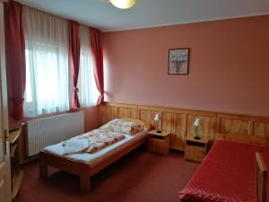 瑙吉考尼饶Medgyaszay Panzió的一间卧室配有一张床和两张带台灯的桌子。