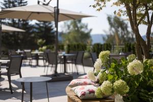 阿维兰奥Hotel Salten的庭院配有桌椅和鲜花以及雨伞。