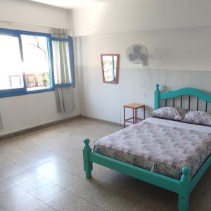 门多萨rafa's house的一间卧室设有绿色的床和2个窗户。