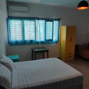 门多萨rafa's house的一间卧室配有床和蓝色窗帘的窗户
