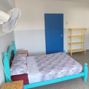 门多萨rafa's house的一间卧室配有蓝色的床和风扇