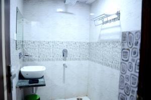 占西Hotel hari palace的白色的浴室设有水槽和淋浴。