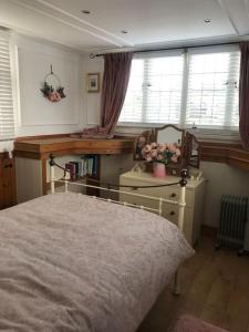 Saint OsythToosey Lass - St Osyth creek的卧室配有一张床、一张书桌和窗户。
