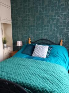 卡斯莱兰Home Comforts的一间卧室配有一张带绿色棉被的床