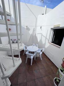 塞博河畔卡莱塔La casita de Yolanda的阳台配有桌椅和电视。