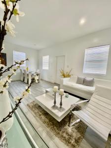 迈阿密Modern & New,Excellent Location Miami的客厅配有白色家具和玻璃地板