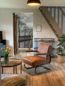 BeilenVakantiehuis Bed en Breakfast in de Tuin的一间带椅子和楼梯的客厅