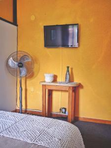 吉亚迪诺镇HERMOSO ALOJAMIENTO TEMPORARIO KAYA的一间卧室配有电视和一张带风扇的桌子。