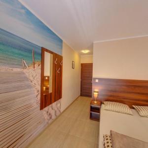 罗威Willa Amber的一间设有卧室的客房,卧室内装饰有海滩壁画