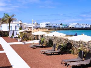 塞博河畔卡莱塔La Graciosa Camelia Beach Vistas Mar的海滩上的一组椅子和遮阳伞