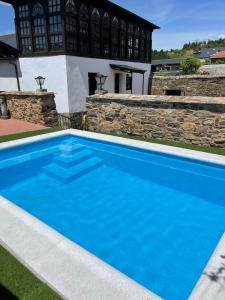Villar de los BarriosCasona Las Burillas的房子前面的蓝色游泳池