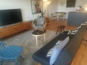 新考蓬基Ylimmän kerroksen luksusnäkymät ydinkeskustassa的客厅配有沙发、椅子和电视