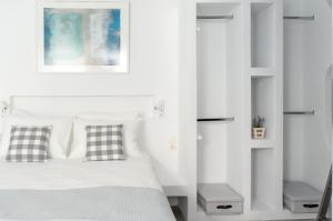 帕罗奇亚Pelican Paros的卧室拥有白色的墙壁,配有一张带两个枕头的床