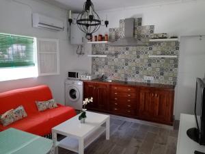 奇克拉纳－德拉弗龙特拉Casa tranquila , muy bien ubicada的一间带红色沙发的客厅和一间厨房