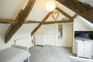 卡迪根Castle Cottage的一间卧室配有一张床,天花板拥有横梁