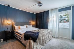 DomsjöSpacious Villa located in Beautiful High Coast的一间卧室配有一张蓝色墙壁的床和一扇窗户