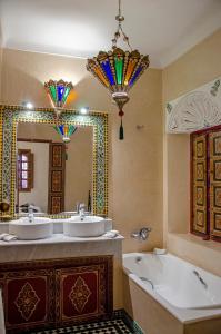 马拉喀什Riad Esmeralda的浴室设有2个水槽、浴缸和镜子