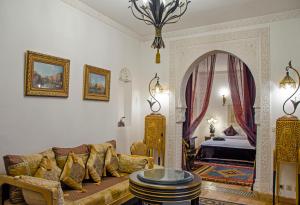马拉喀什Riad Esmeralda的客厅配有沙发和1张床