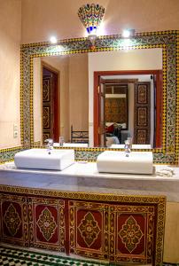 马拉喀什Riad Esmeralda的一间带两个盥洗盆和大镜子的浴室