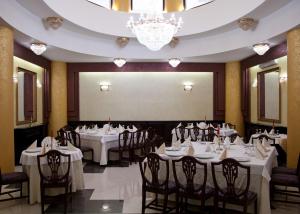 雅西Hotel Majestic的餐厅配有白色的桌椅和投影屏幕
