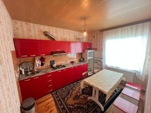 库巴Orchard的一间厨房,里面装有红色橱柜和一张桌子