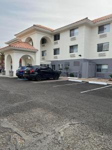 梅萨Holiday Inn Express & Suites Phoenix - Mesa West, an IHG Hotel的停在大楼前停车场的汽车