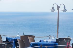 卡拉恩波特Hotel Sa Barrera - Adults Only的一张桌子,上面有蓝色的桌子和椅子,后面有海洋