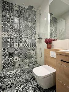 华沙Smart Apartment Ogrodowa的浴室设有黑色和白色瓷砖淋浴。