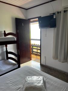 阿拉夏奇巴海滩Luar de Araçatiba Suítes的一间卧室设有一张床,并有通往阳台的门