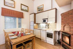 卡拉约基塔皮图帕公寓的厨房配有木桌和壁炉。
