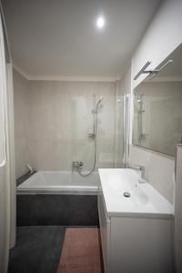 罗马Angelico Luxury House的白色的浴室设有浴缸和水槽。