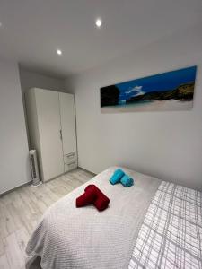 阿利坎特Ravel的一间卧室配有一张带红色和蓝色毛巾的床