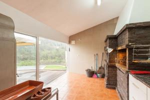辛方伊什Casa da Barragem Douro的厨房设有石制壁炉和大窗户。