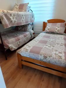 弗鲁蒂亚尔Casa a 5 minutos del balneario的一间卧室设有两张床,铺有木地板