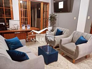 纳斯卡Hostal Casa de Ana的带沙发和椅子的客厅以及书桌。