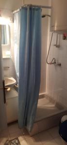比克Adikati Lak的一间带蓝色淋浴帘的淋浴的浴室