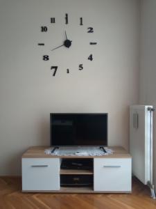 大格拉迪什泰Apartman STANKOVIĆ的墙上的时钟,墙上有电视