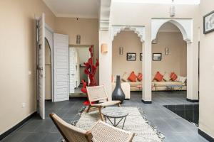 马拉喀什艾姆派尔摩洛哥传统庭院住宅的客厅配有两把椅子和一张沙发