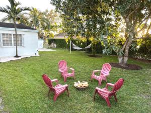 迈阿密Home in Miami的院子里有四把粉红色的椅子和一个火坑