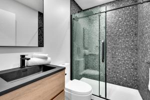 蒙特利尔Deluxe Suites Downtown Montreal的带淋浴、卫生间和盥洗盆的浴室