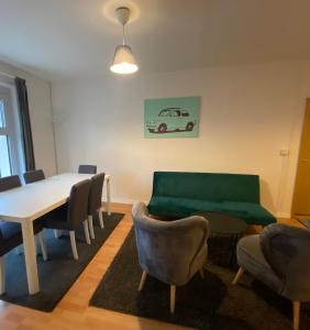 柏林Osthafen III的一间带桌椅和绿色沙发的用餐室